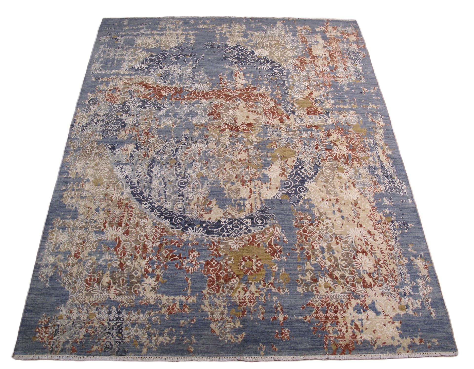Blue, beige, and rust-colored rectangular rug with a circular design and distressed appearance.