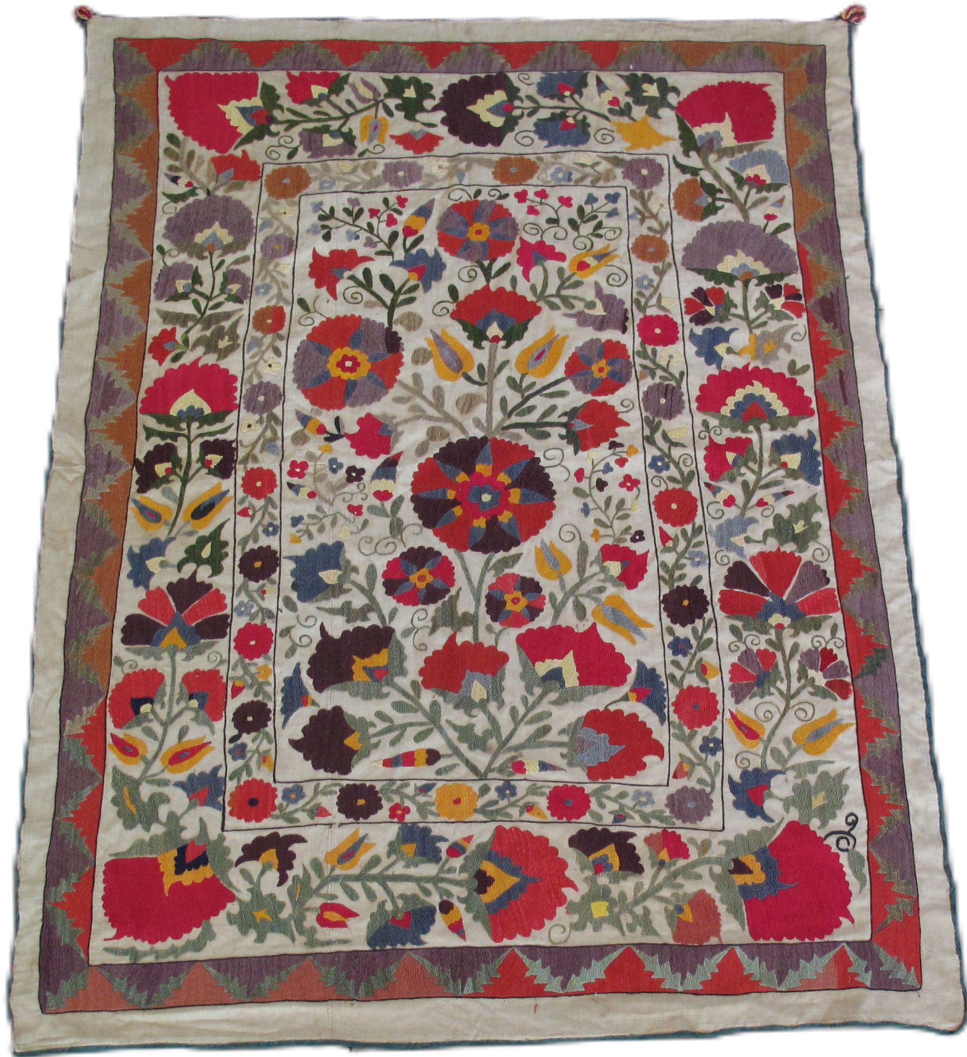 Colorful embroidered textile with floral designs and geometric border.