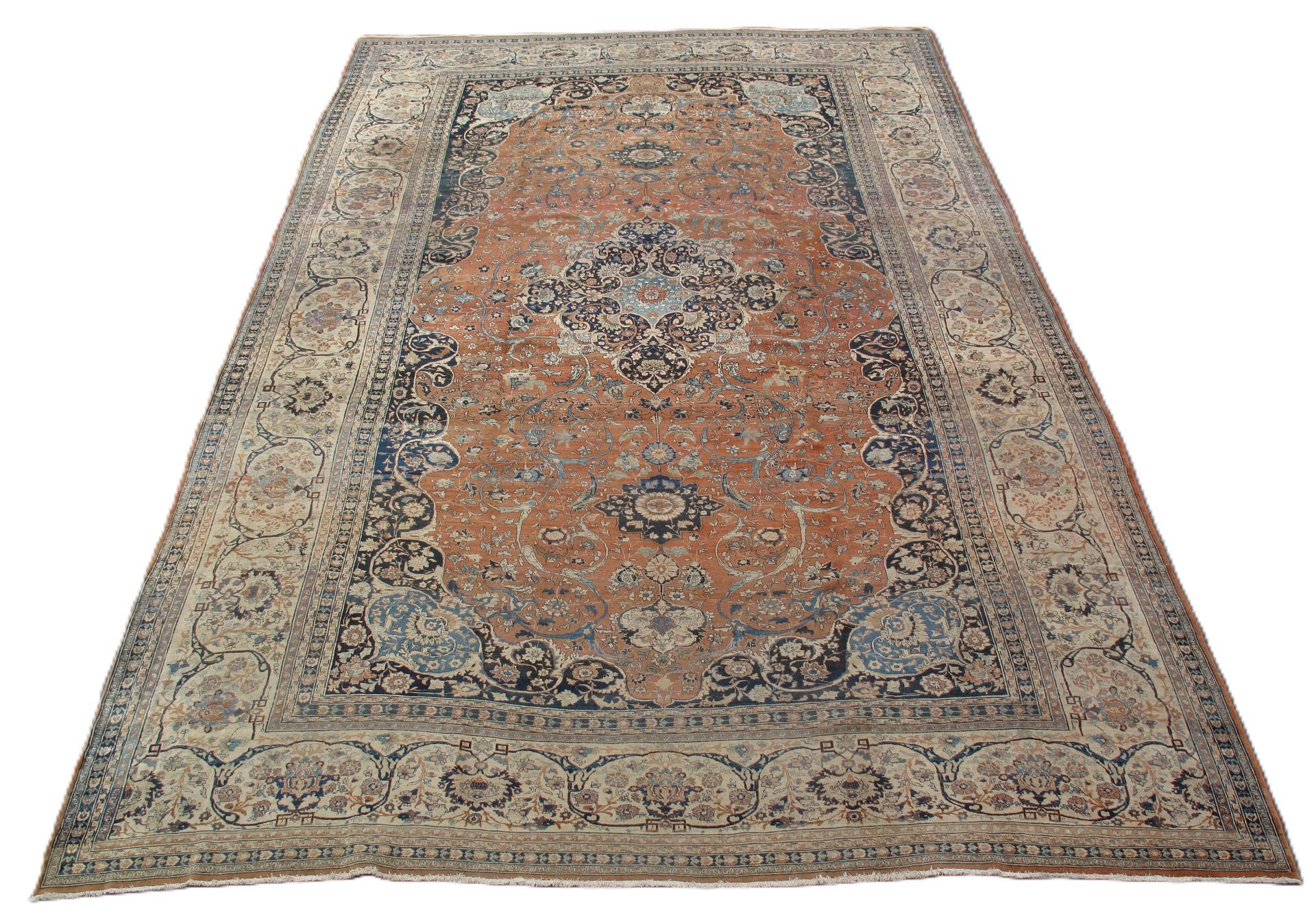 Vintage patterned rug in faded orange, beige, and blue, shown on a white background.