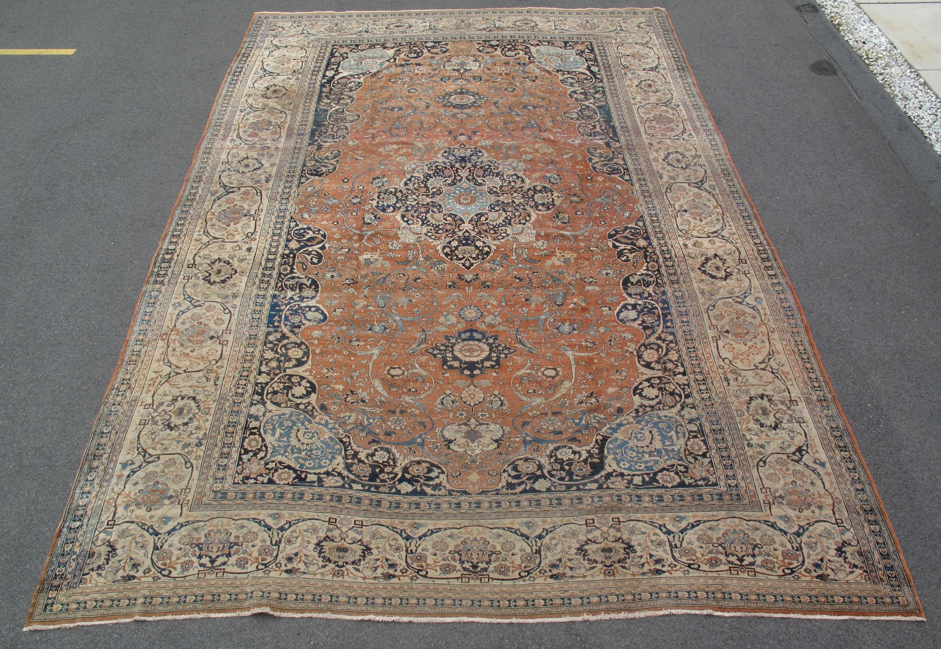 Vintage patterned rug in faded orange, beige, and blue, shown on a white background.