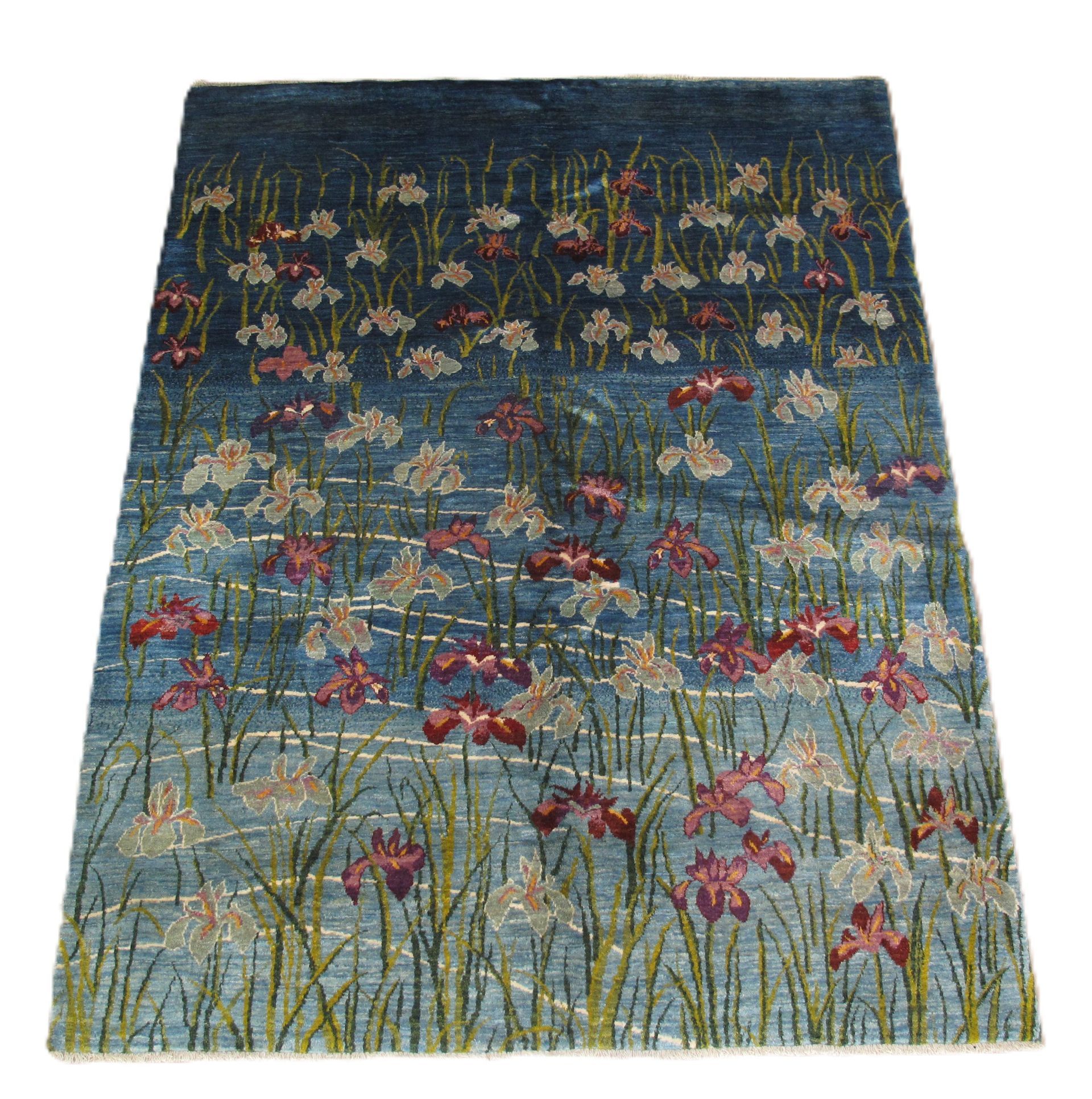 Floral rug with blue background, red and white flowers, and green stalks.