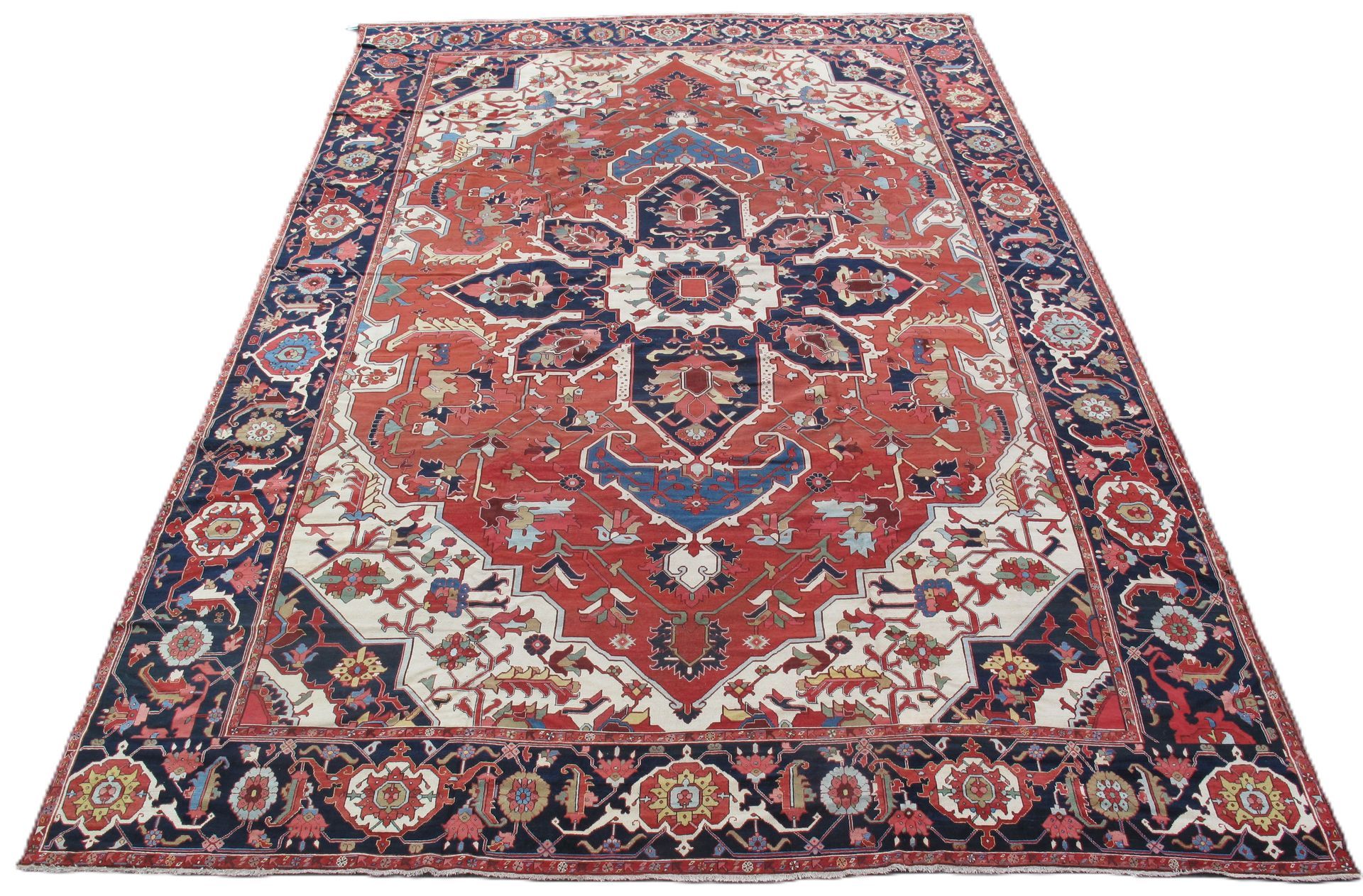 Patterned red and navy oriental area rug with ornate floral border, shown on a white background