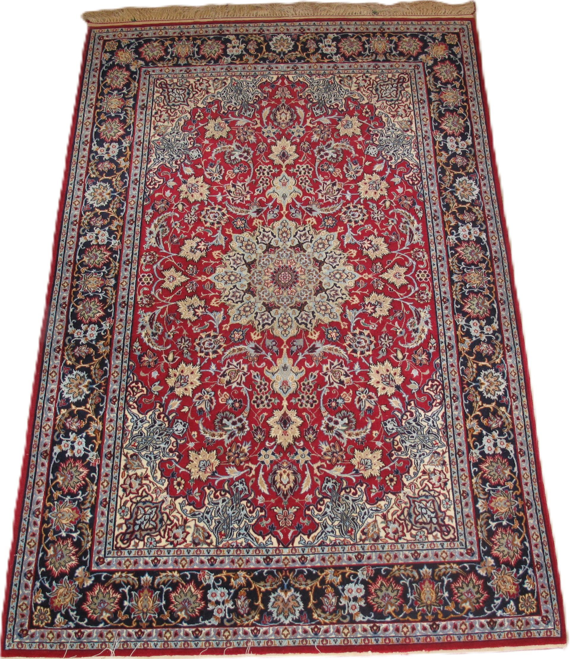 Red and navy Persian rug with floral pattern, ivory medallion, and fringed edge.