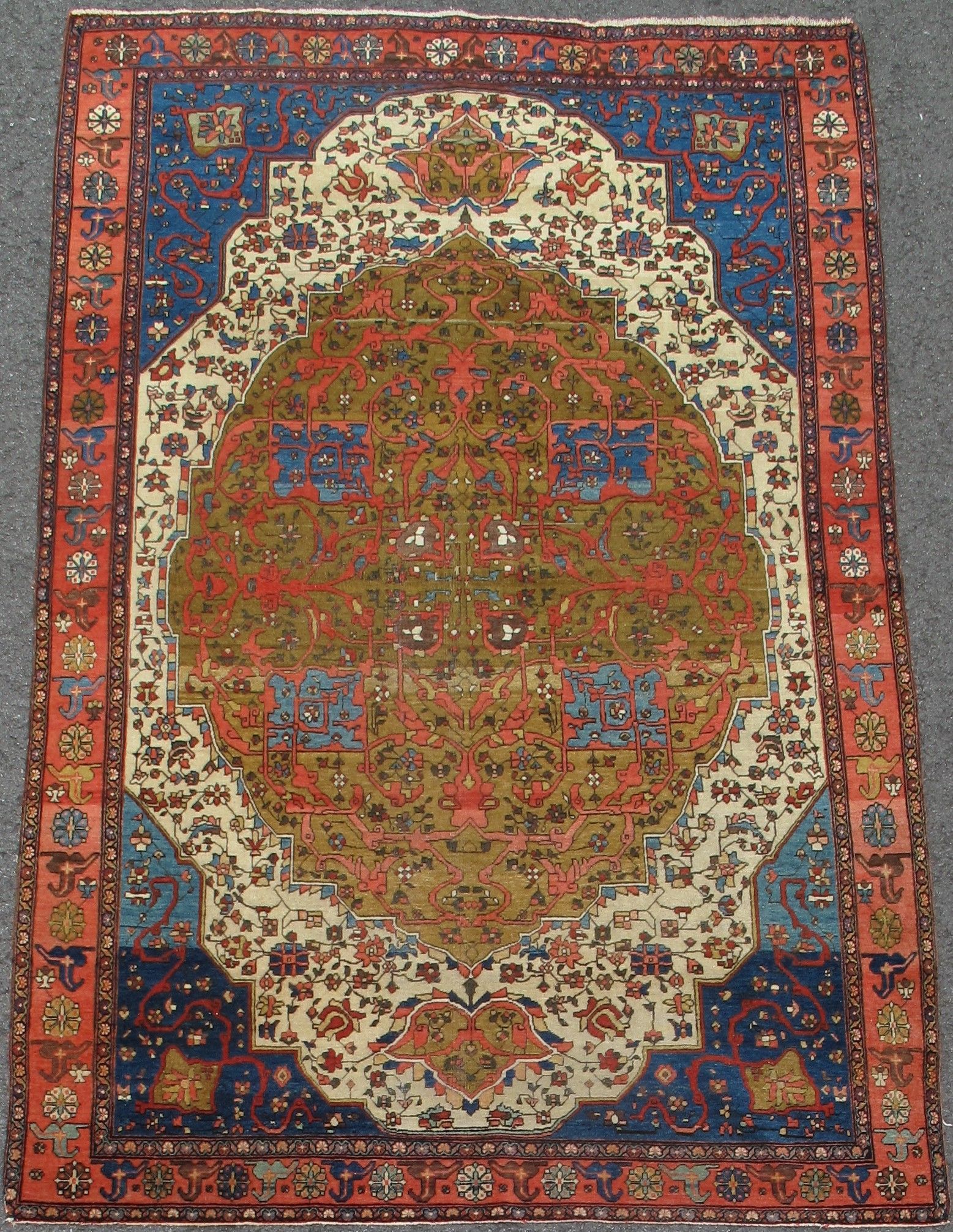 Decorative red, blue, and cream patterned rug with a large central medallion.