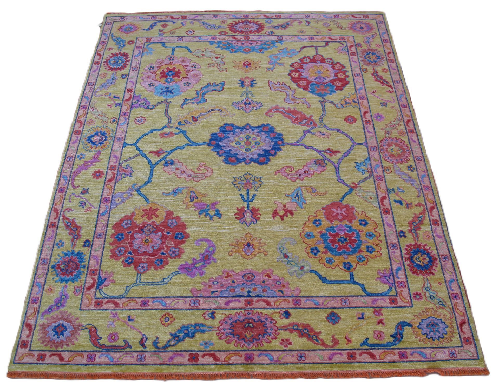 Yellow rug with floral pattern in pink, blue, and red.