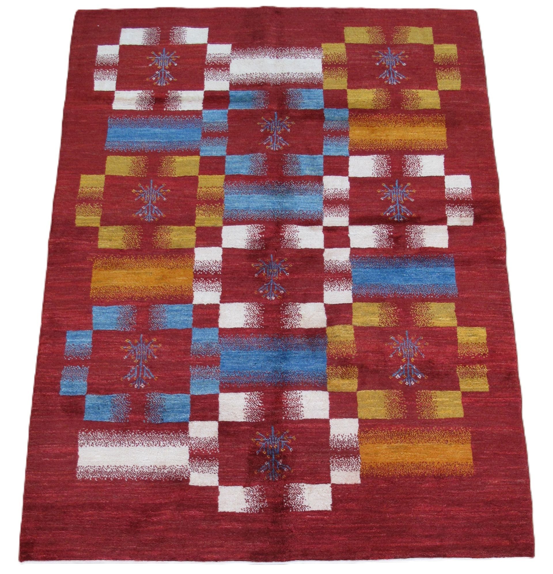 Red rug with a geometric design in blue, white, and yellow squares.