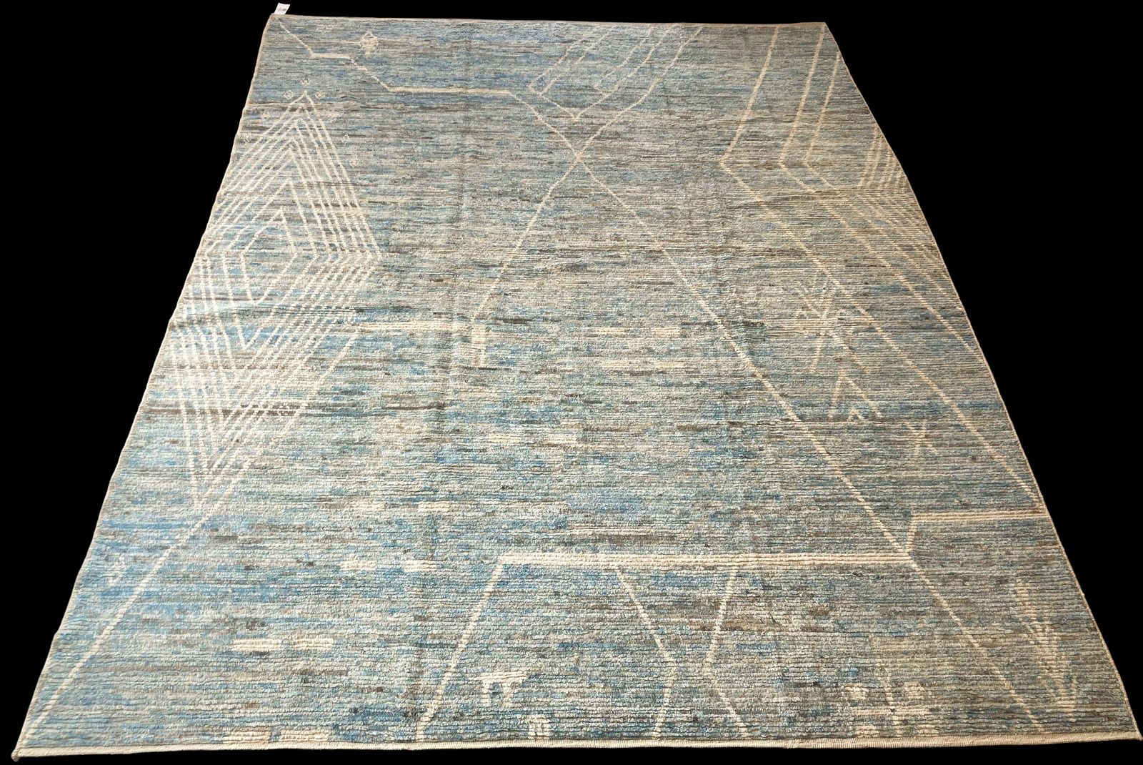 A blue and white rug is sitting on a black surface.