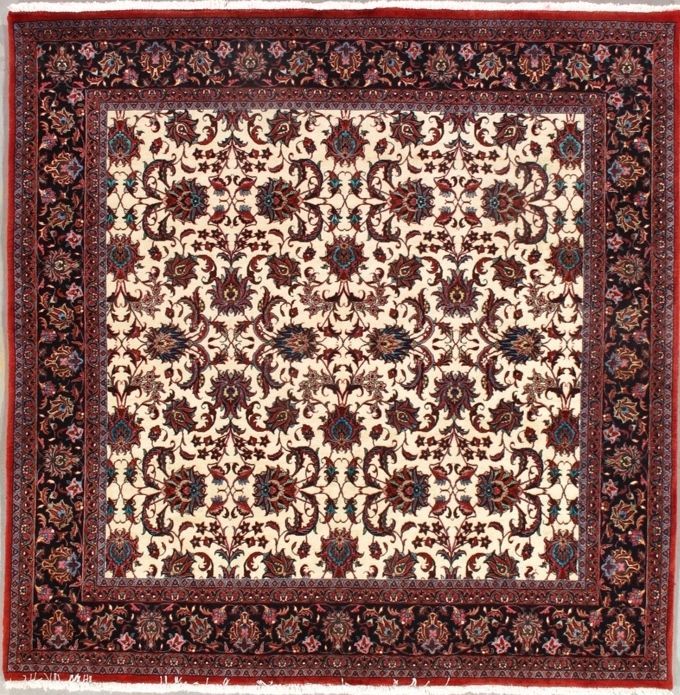 Square cream-colored rug with floral patterns in brown and blue, framed by a dark border with floral design.
