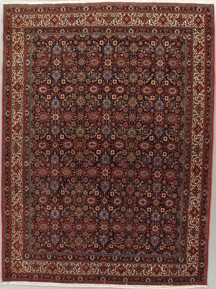 Oriental rug with a dark field, floral motifs, and a patterned border in red and cream.