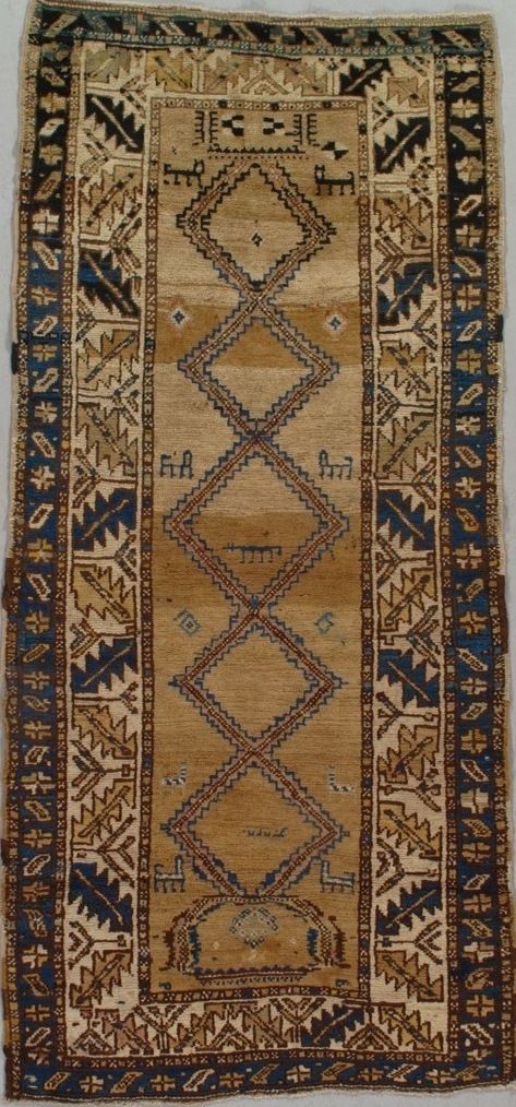 Tan and dark blue antique rug with diamond and geometric patterns.