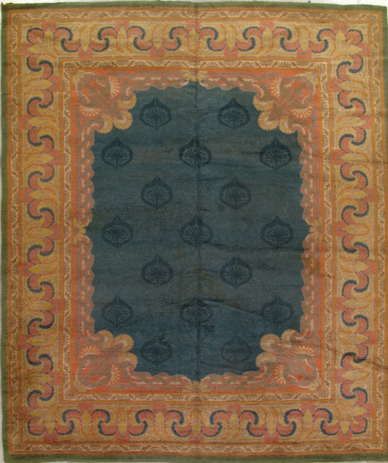 Antique rug with navy center and ornate peach and gold border.