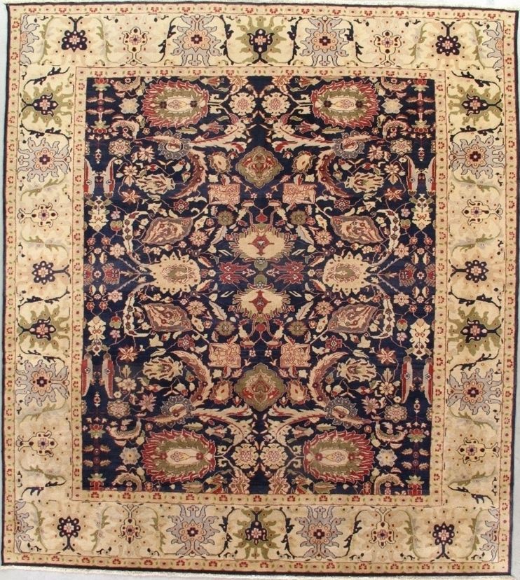 Square rug with a dark blue central field, beige border, and floral motifs.