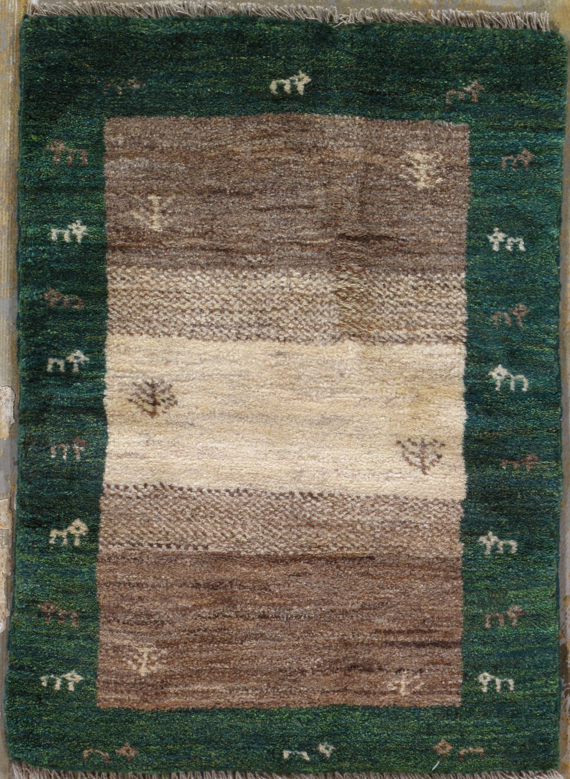 Green and brown rectangular rug with white and brown stripes; houses and trees border.