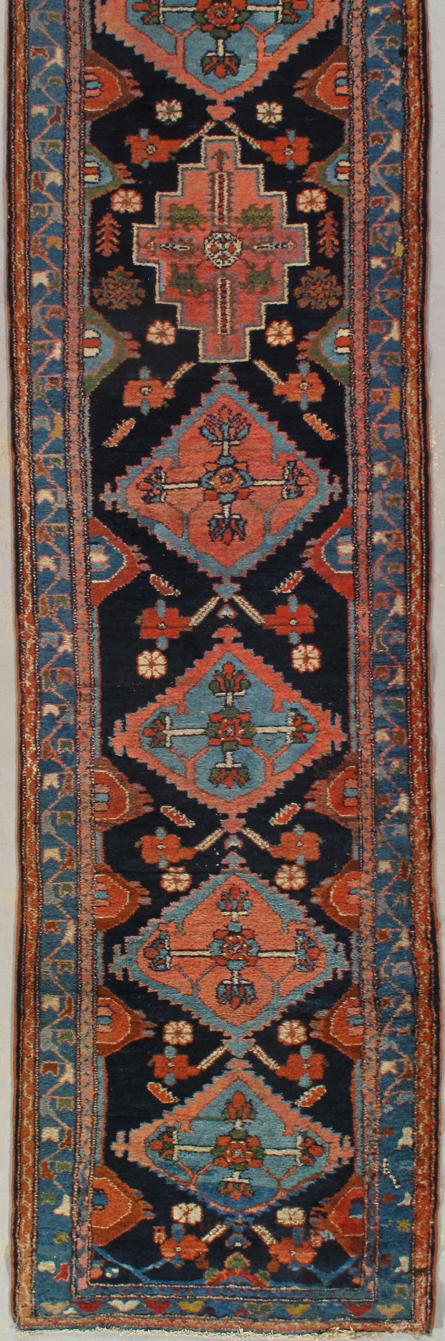 Narrow red and blue patterned oriental rug with floral and geometric motifs