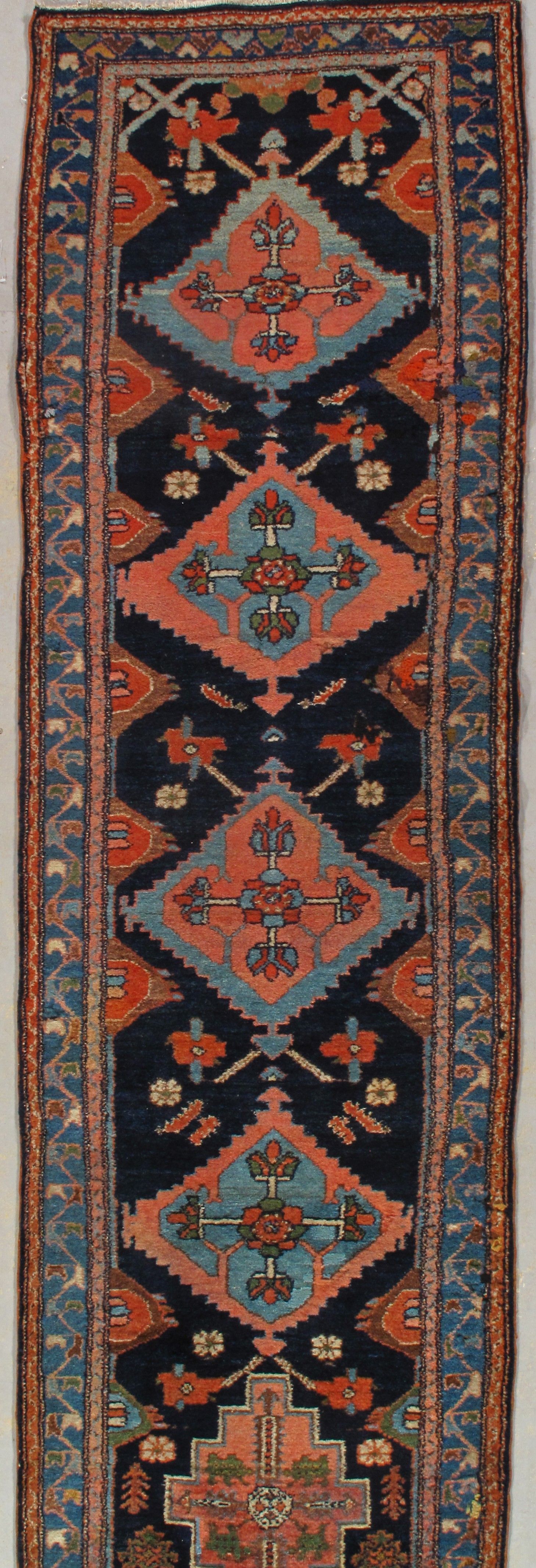 Narrow red and blue patterned oriental rug with floral and geometric motifs
