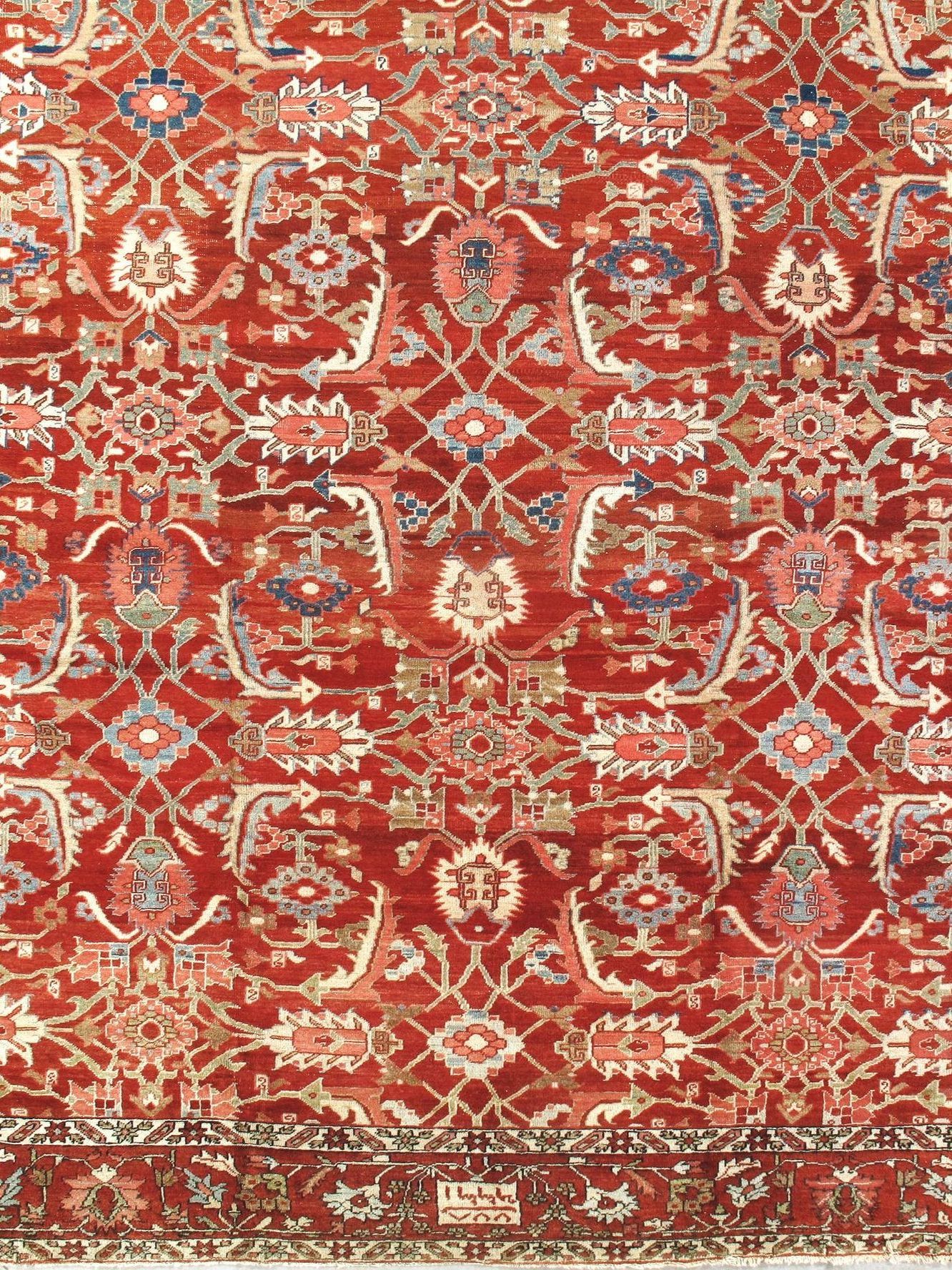 A red rug with a floral pattern is hanging on a wall.