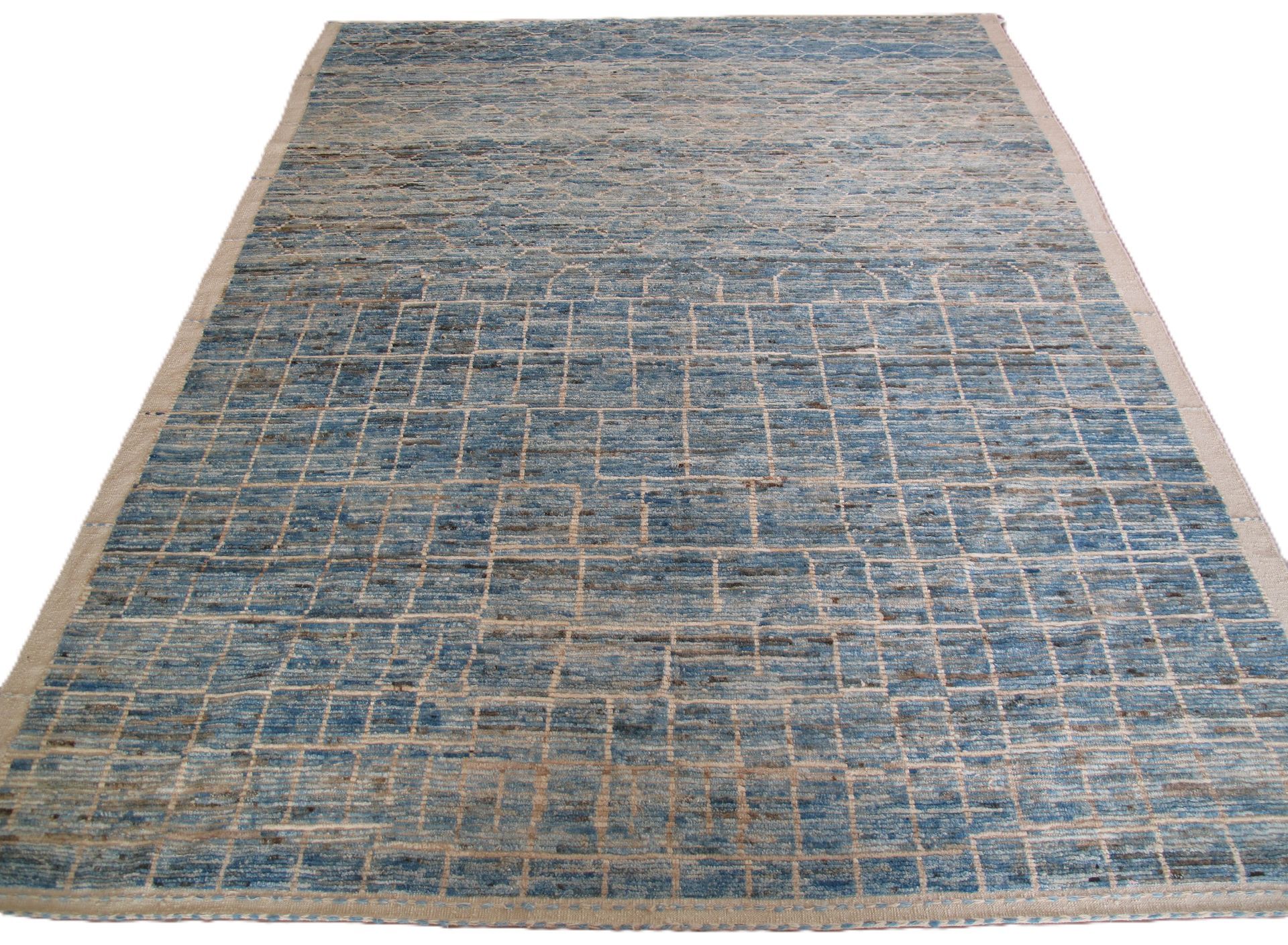Blue and beige patterned area rug on a white background