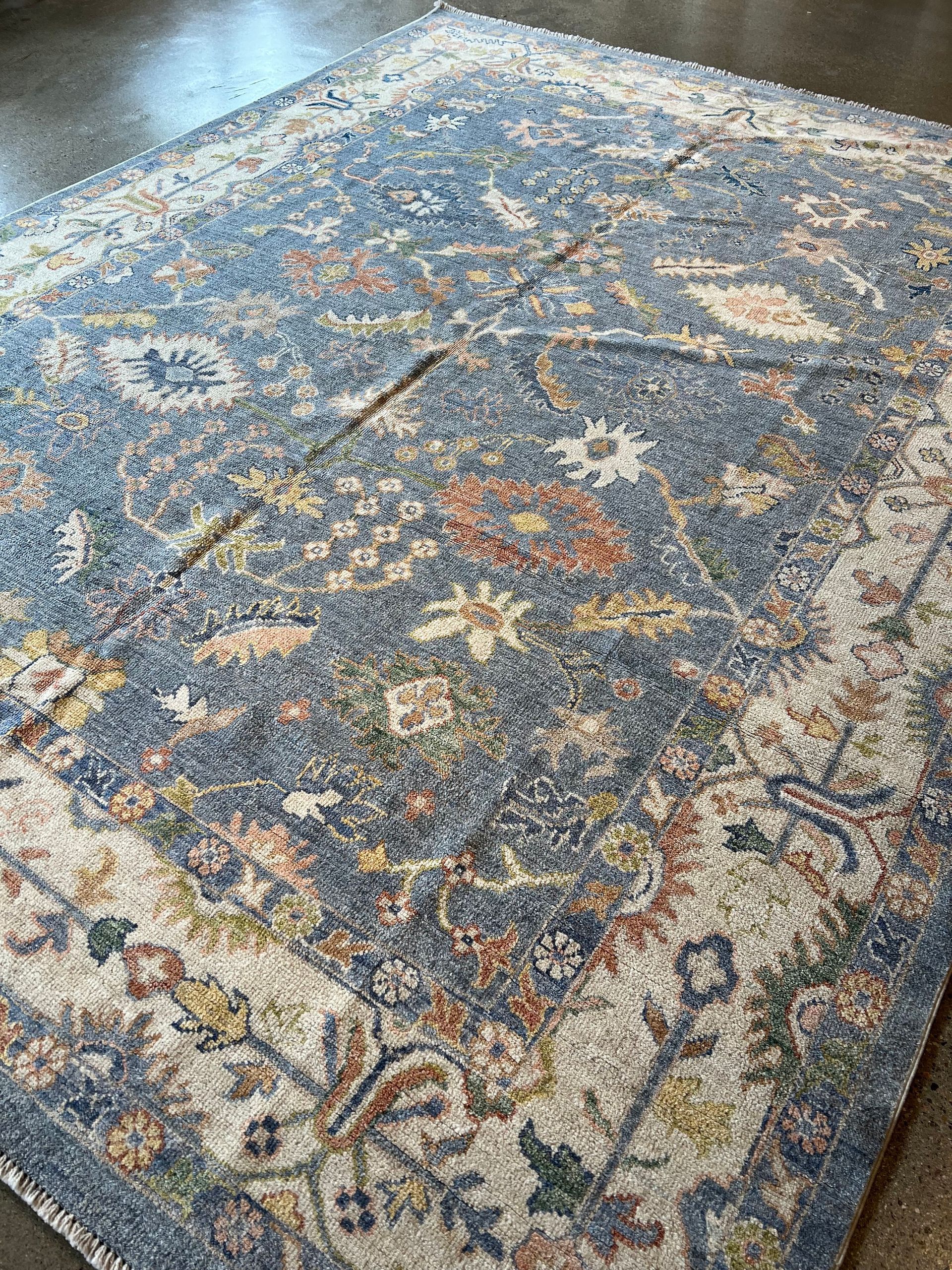 A blue and white rug with a floral pattern on a white background.