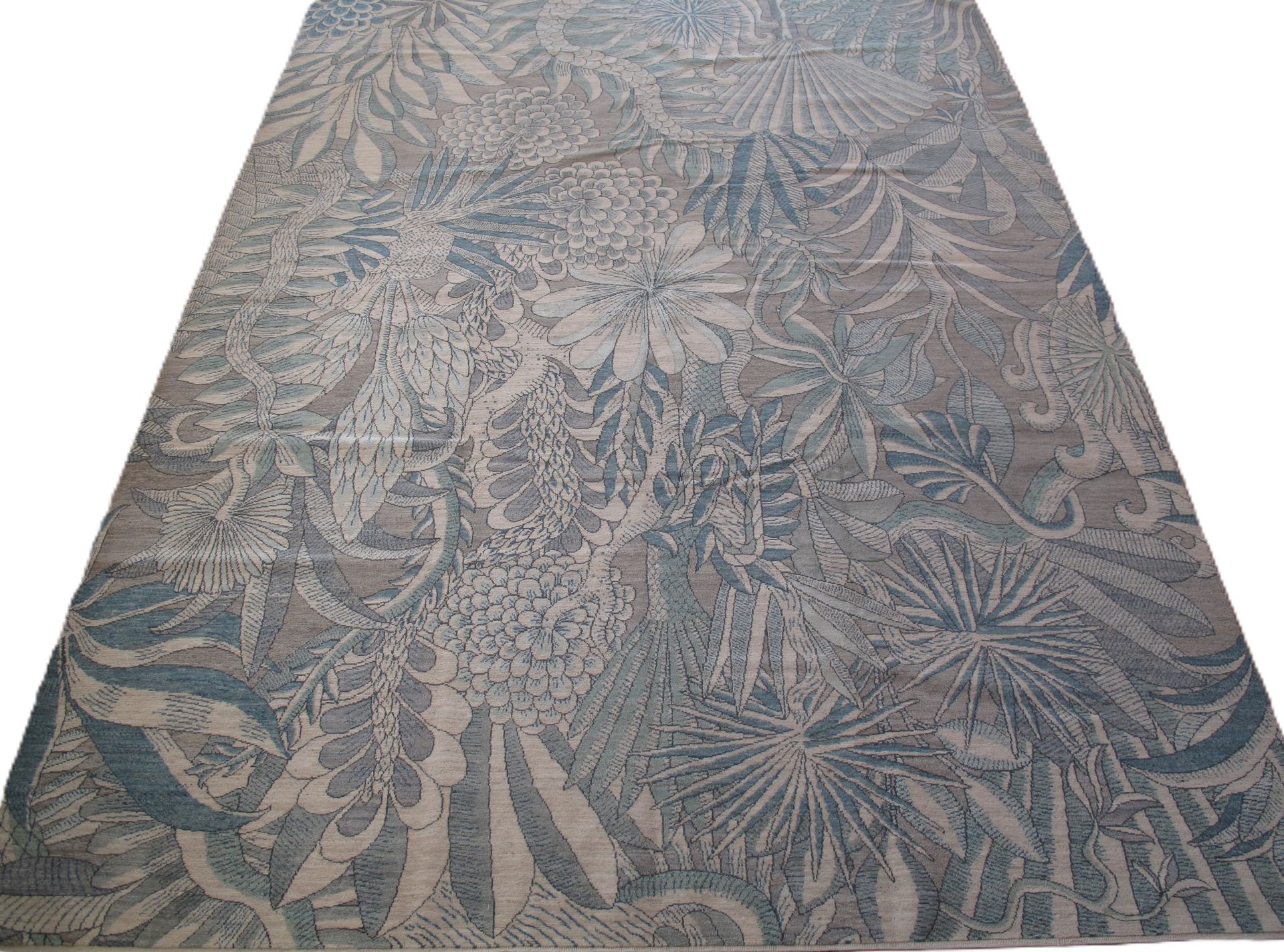 Large rug with blue and beige botanical pattern.