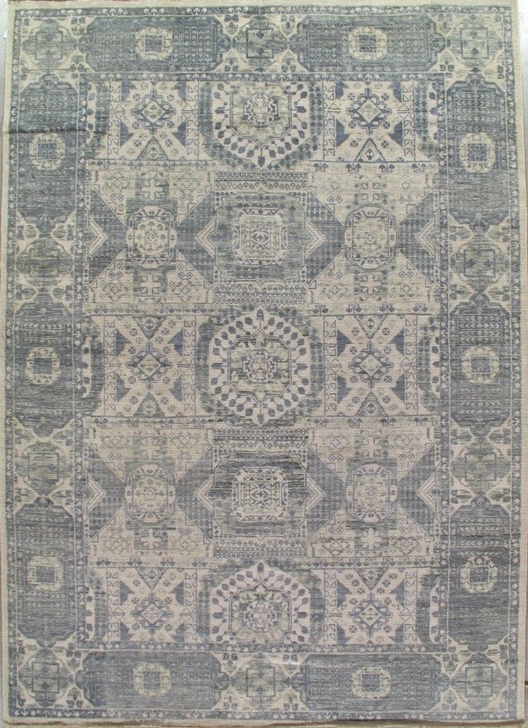 Blue and beige patterned woven rug with geometric and floral motifs