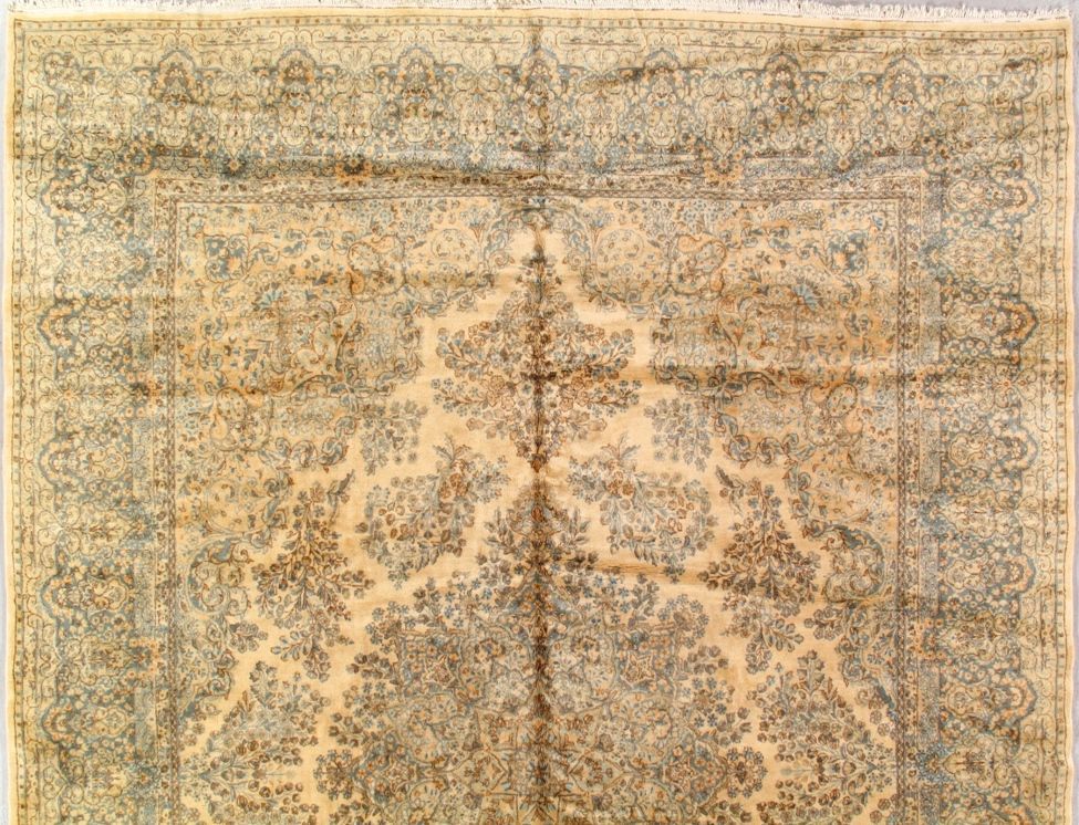 Beige and blue Persian rug with a central floral medallion design and ornate border.