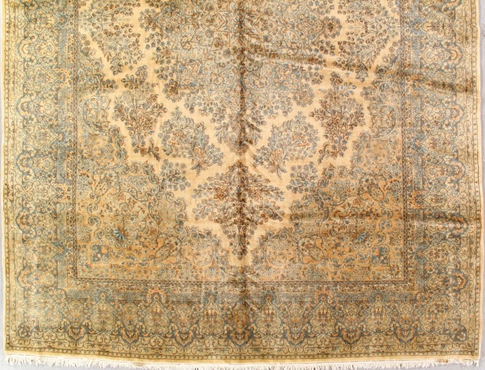Beige and blue Persian rug with a central floral medallion design and ornate border.