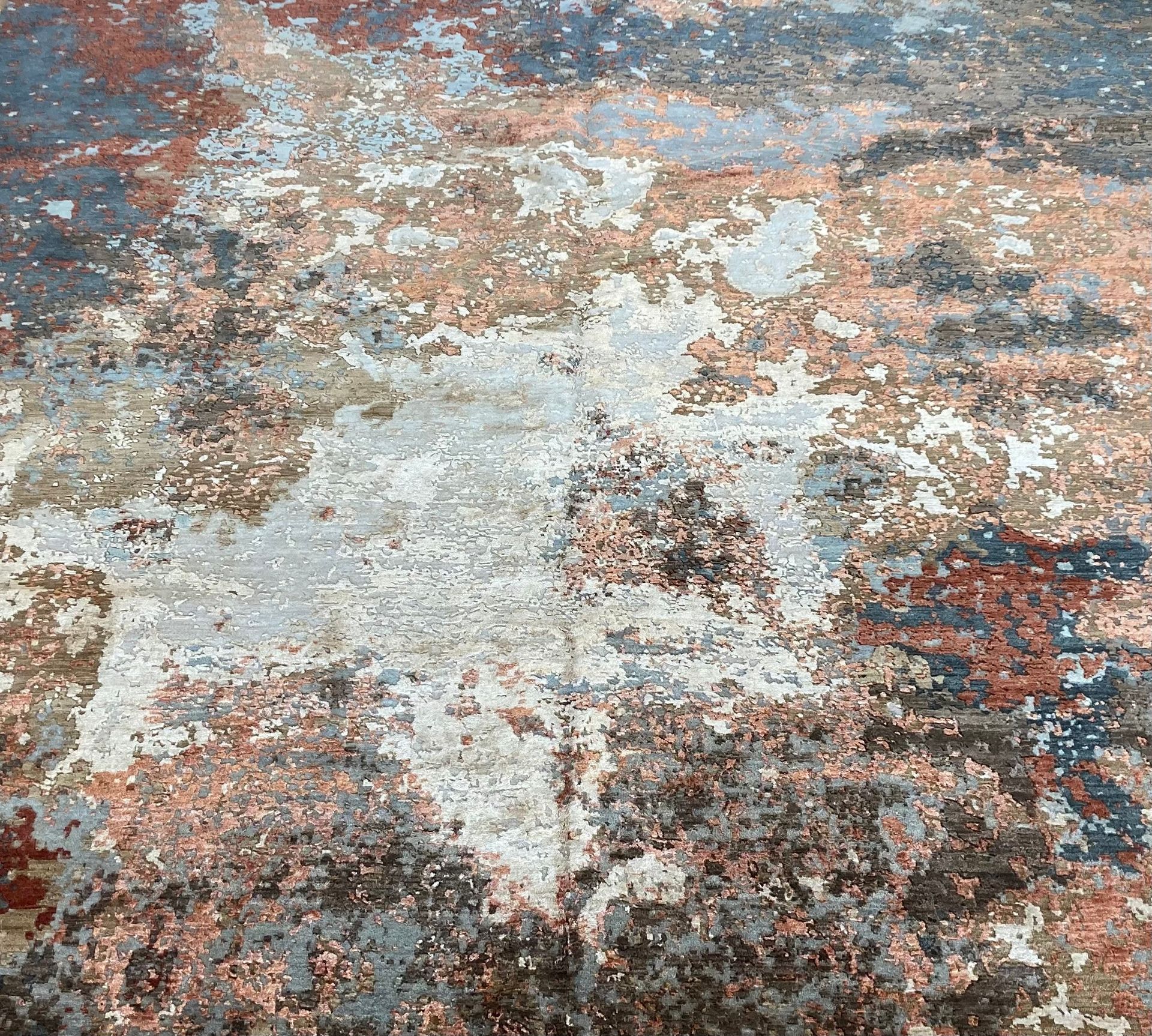 A rug with a painting on it is on a white background.
