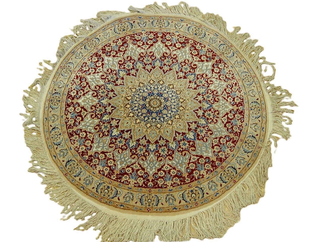 Round Persian rug with red, blue, and cream floral pattern and fringe.