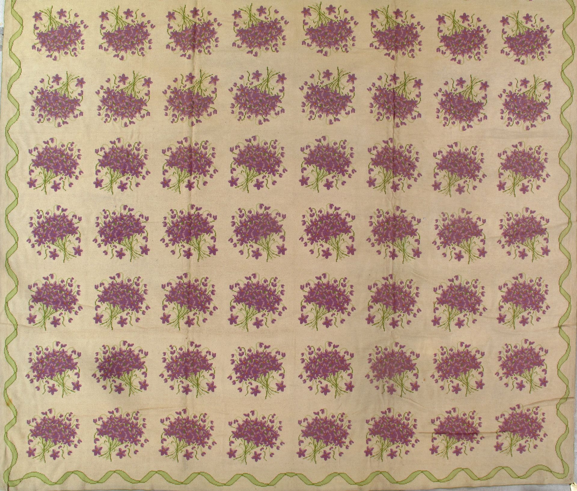 Repeated purple floral pattern on a beige background with a scalloped border