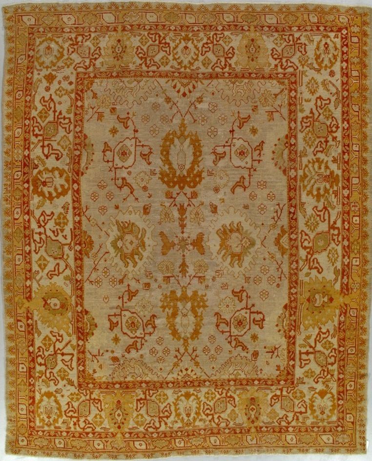 Beige and orange antique Persian rug with floral and geometric patterns.