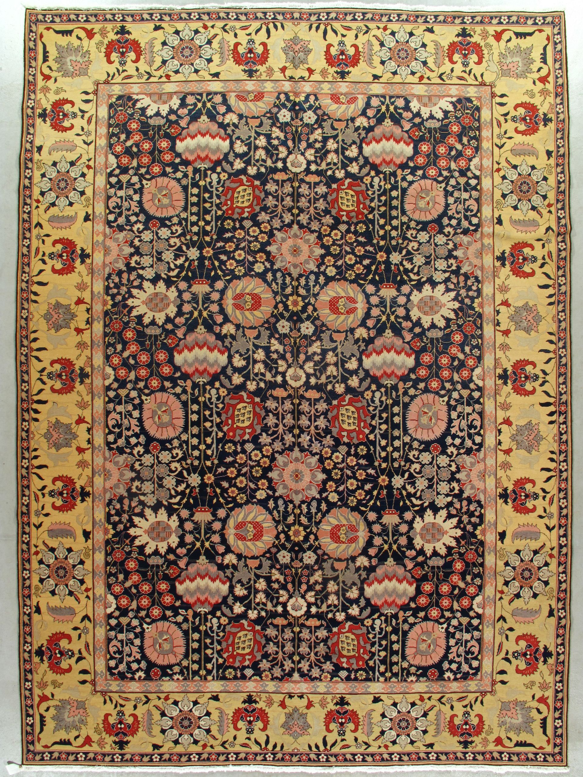 Ornate floral Persian rug with a dark center and cream border on a beige background