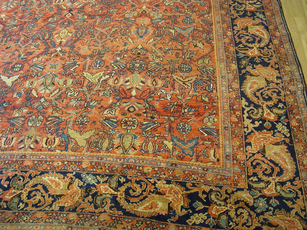 A large rug is sitting on a wooden floor