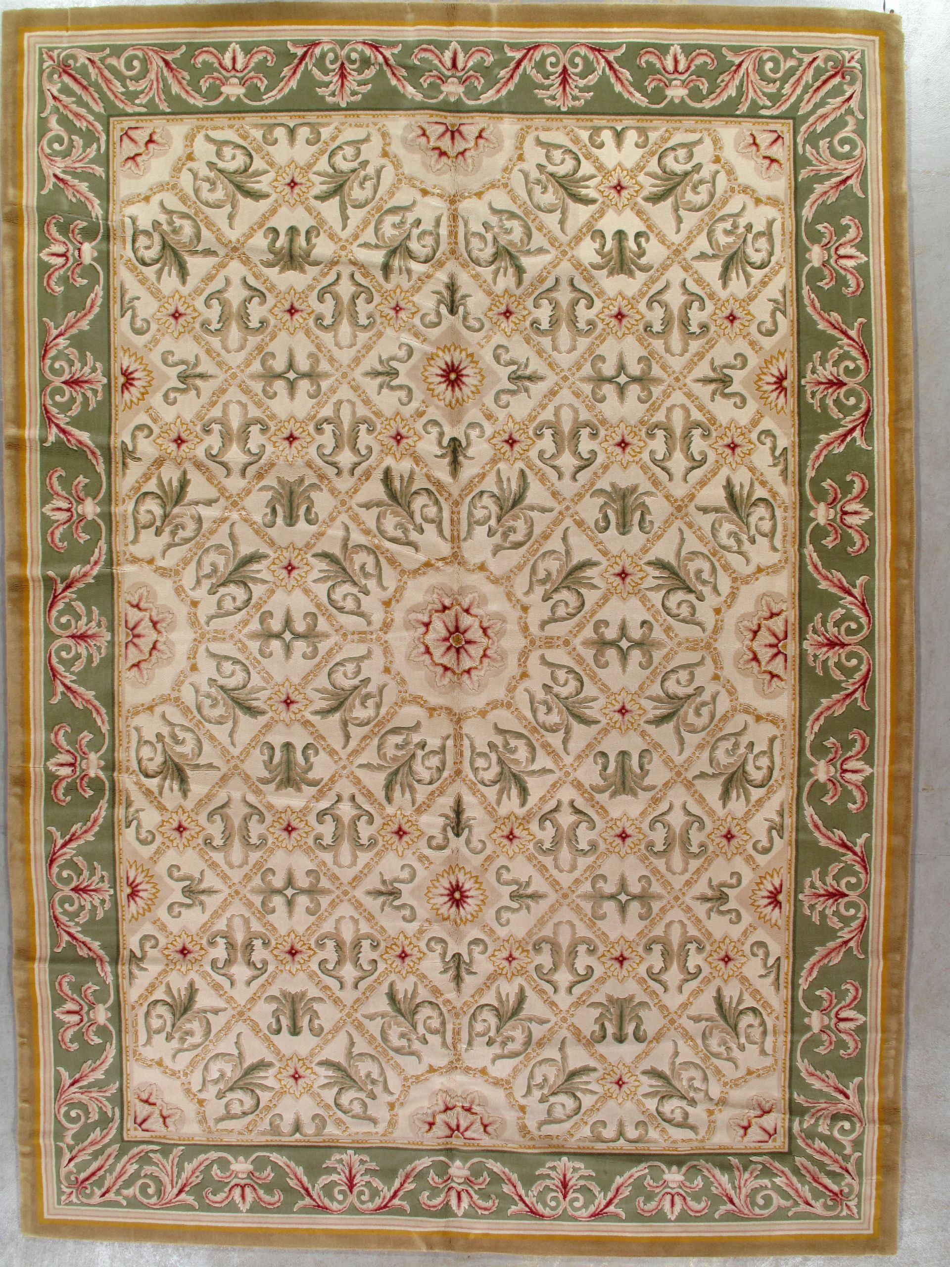 Beige floral patterned area rug with red and green border and central medallion