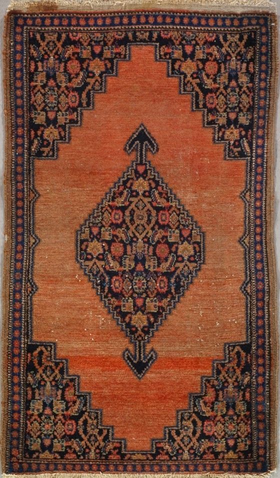Orange and navy rectangular rug with central diamond design and corner patterns.