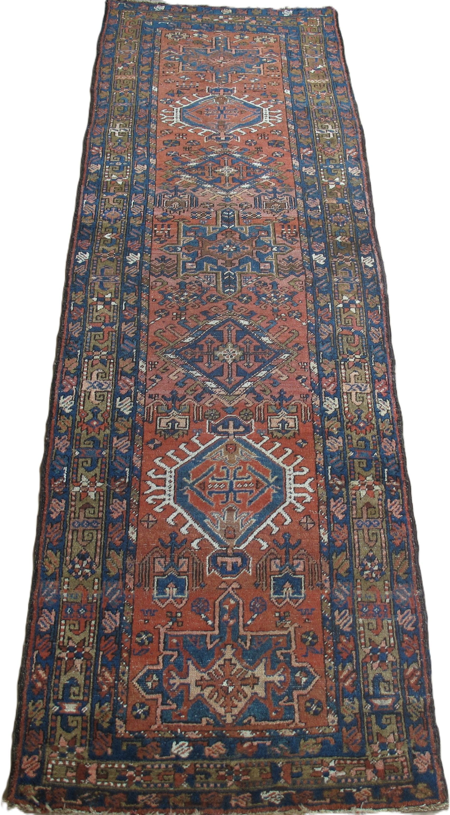 Long, narrow Persian rug; brick red center with blue and cream patterned border.