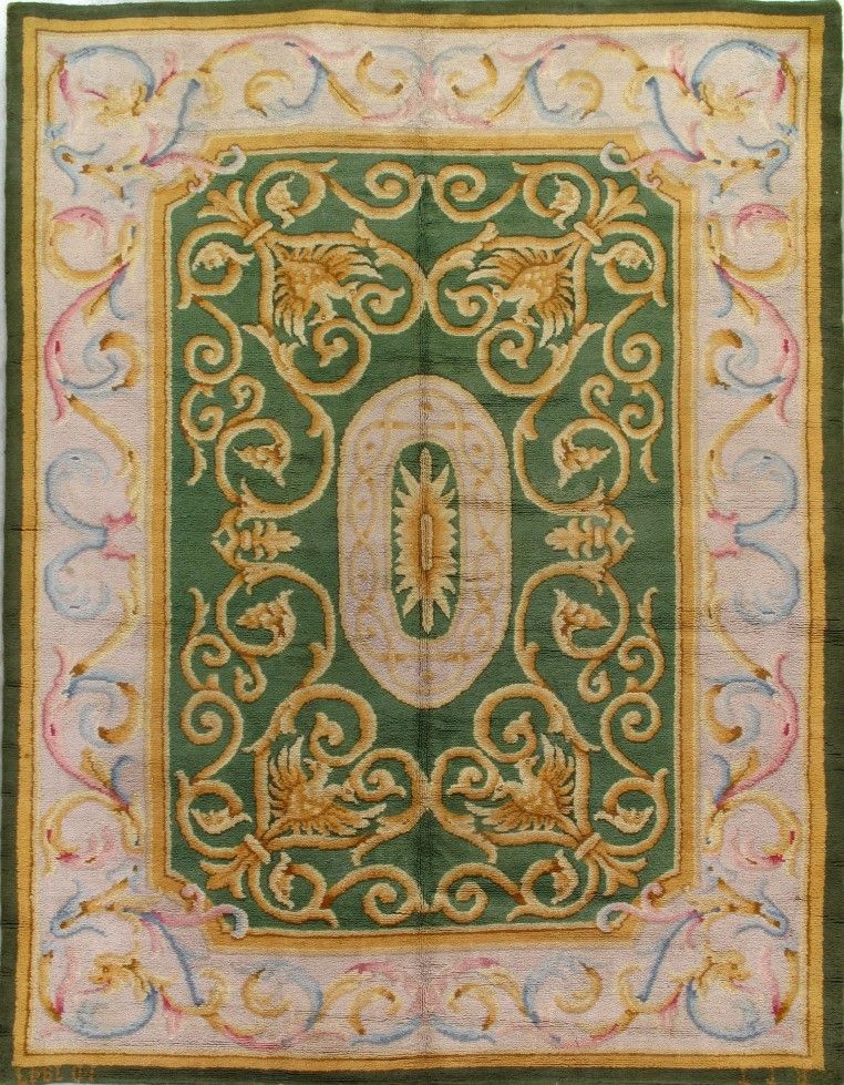 Green and cream rectangular rug with ornate gold and floral designs.