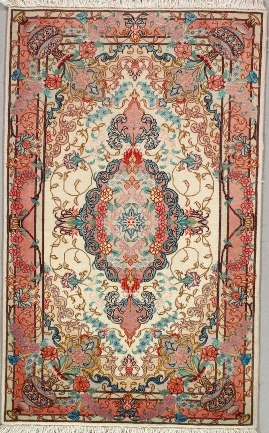Ornate Persian rug with cream background, intricate floral patterns in pink, blue, and gold.