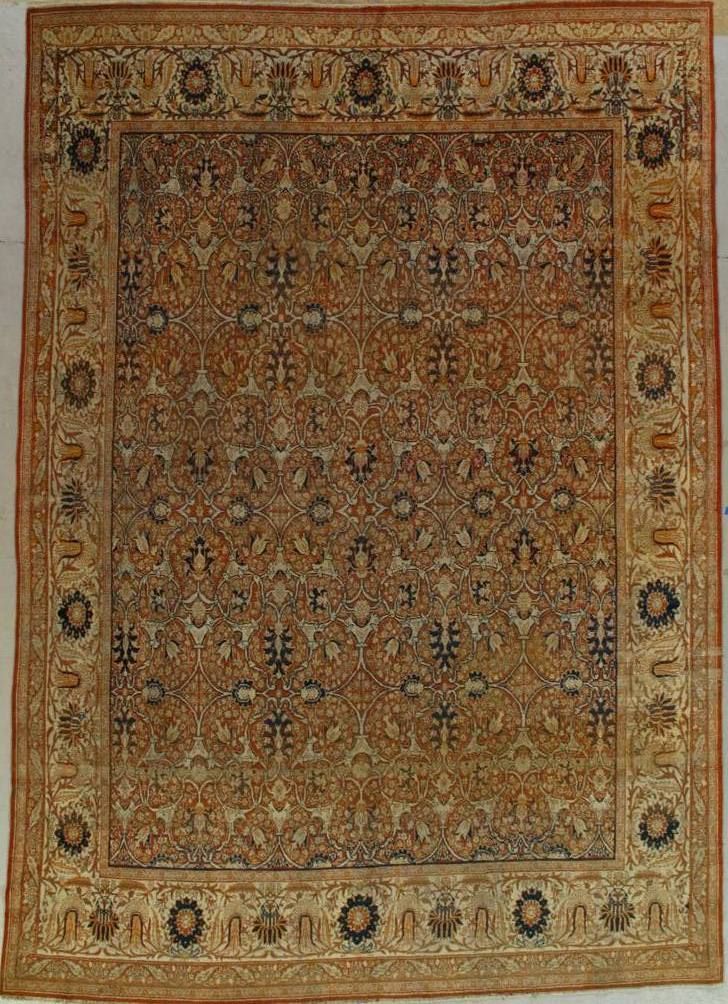 An antique Persian rug with intricate floral patterns in warm tones of brown and gold.