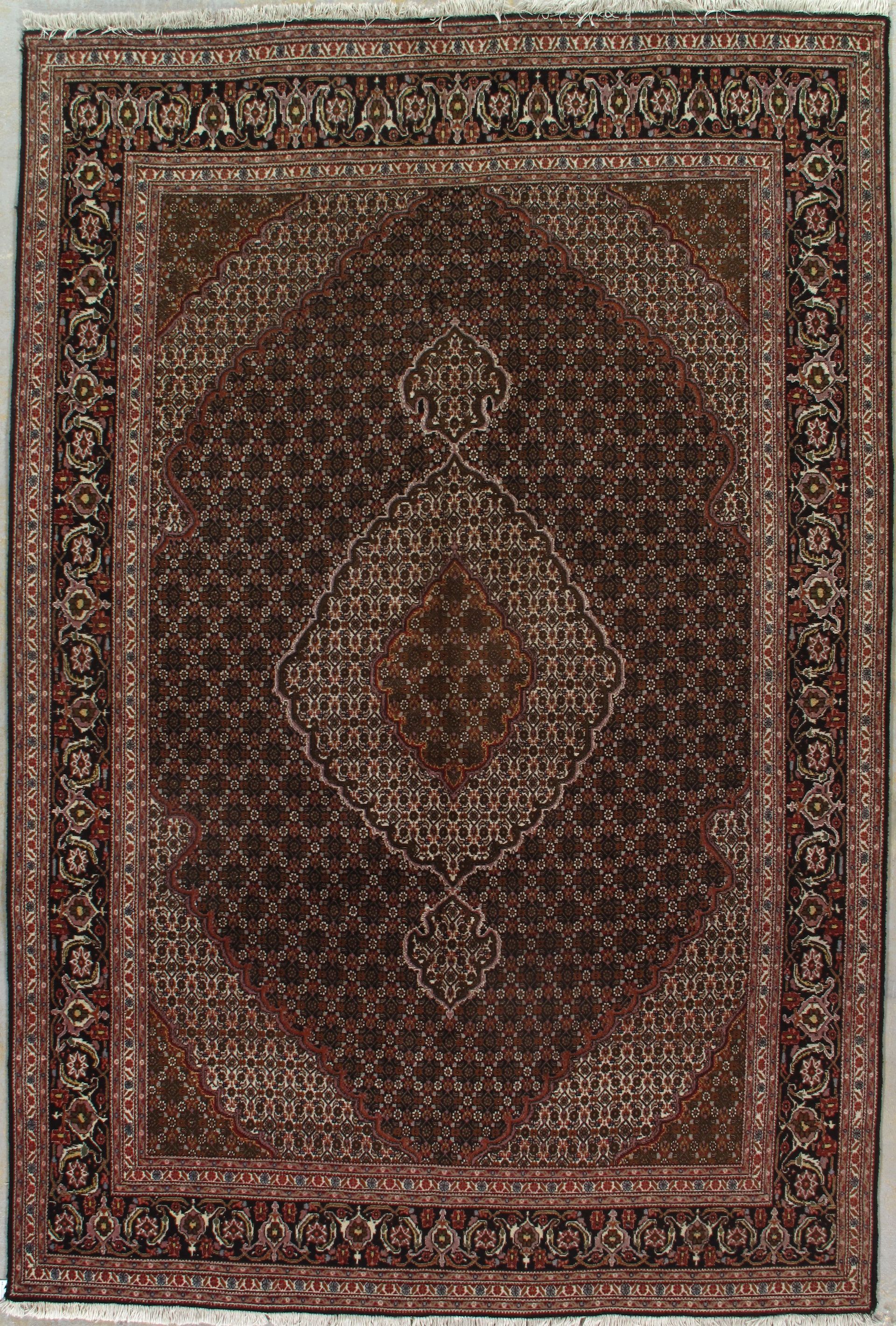 Brown oriental rug with intricate floral border and central medallion.