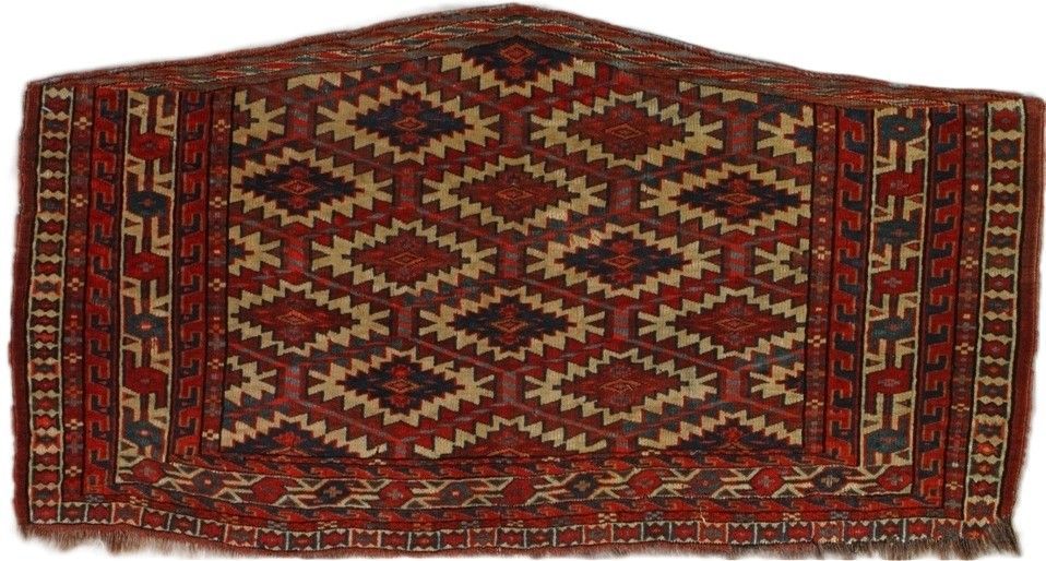 Red, brown, and tan geometric patterned rug with diamond shapes and border detail.