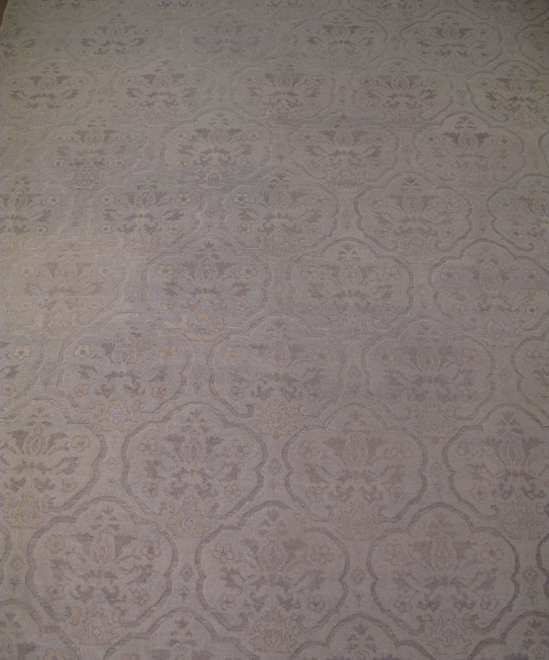 Gray patterned carpet filling the frame with a subtle floral design