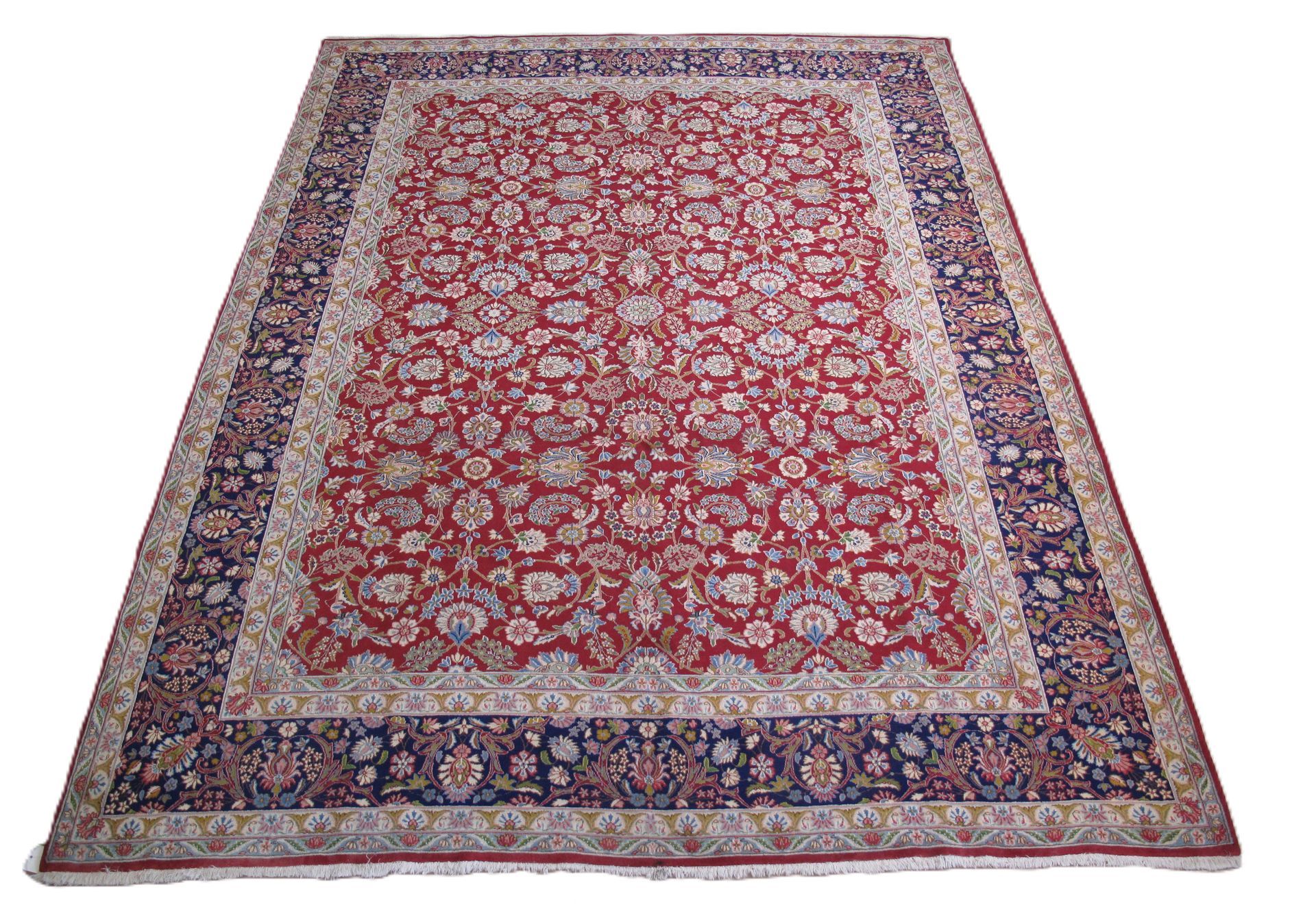 A rectangular Persian-style rug with a red floral pattern, featuring blue and cream borders on a white background.