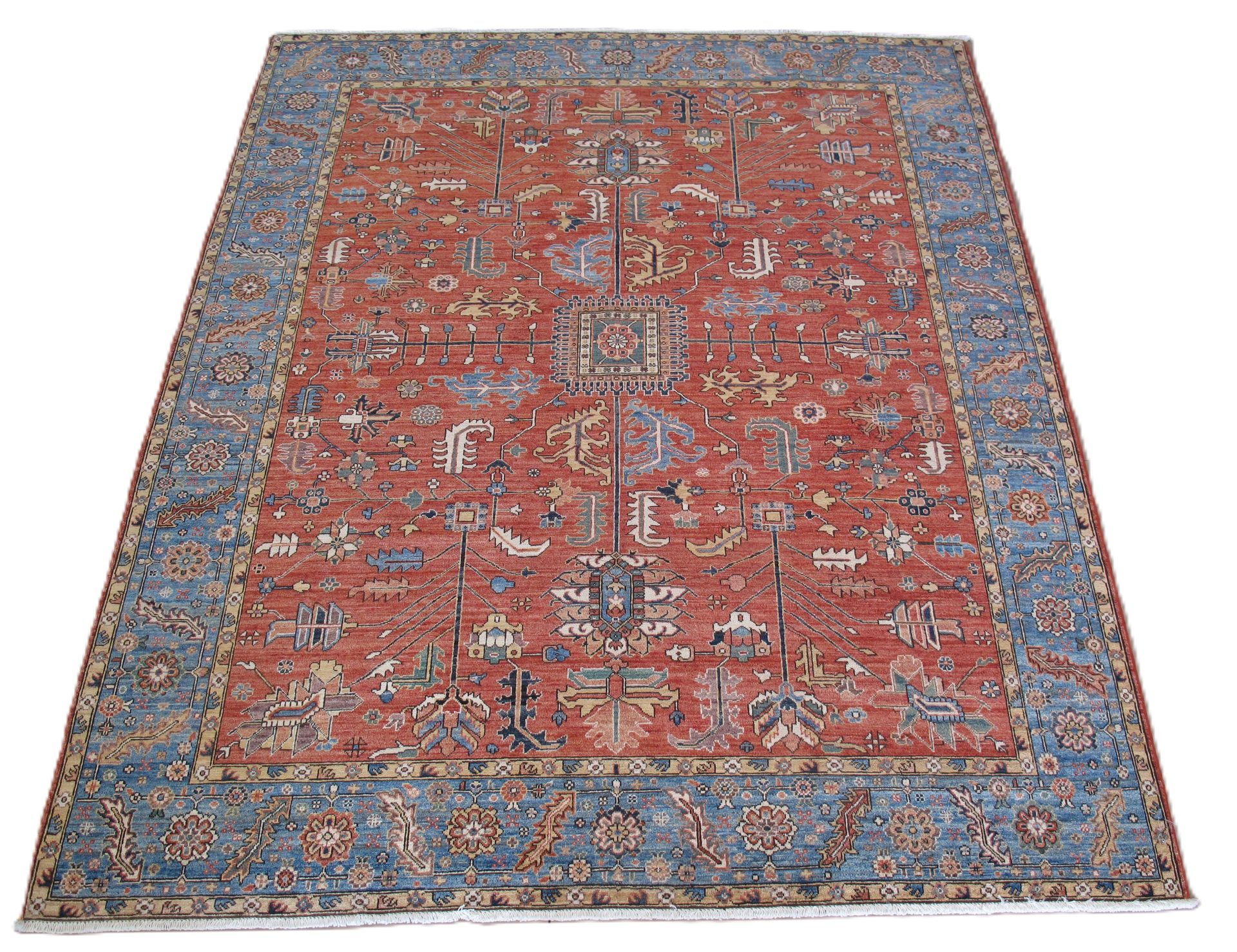 A large, rectangular rug featuring an intricate floral pattern in shades of red, blue, and cream on a light background.