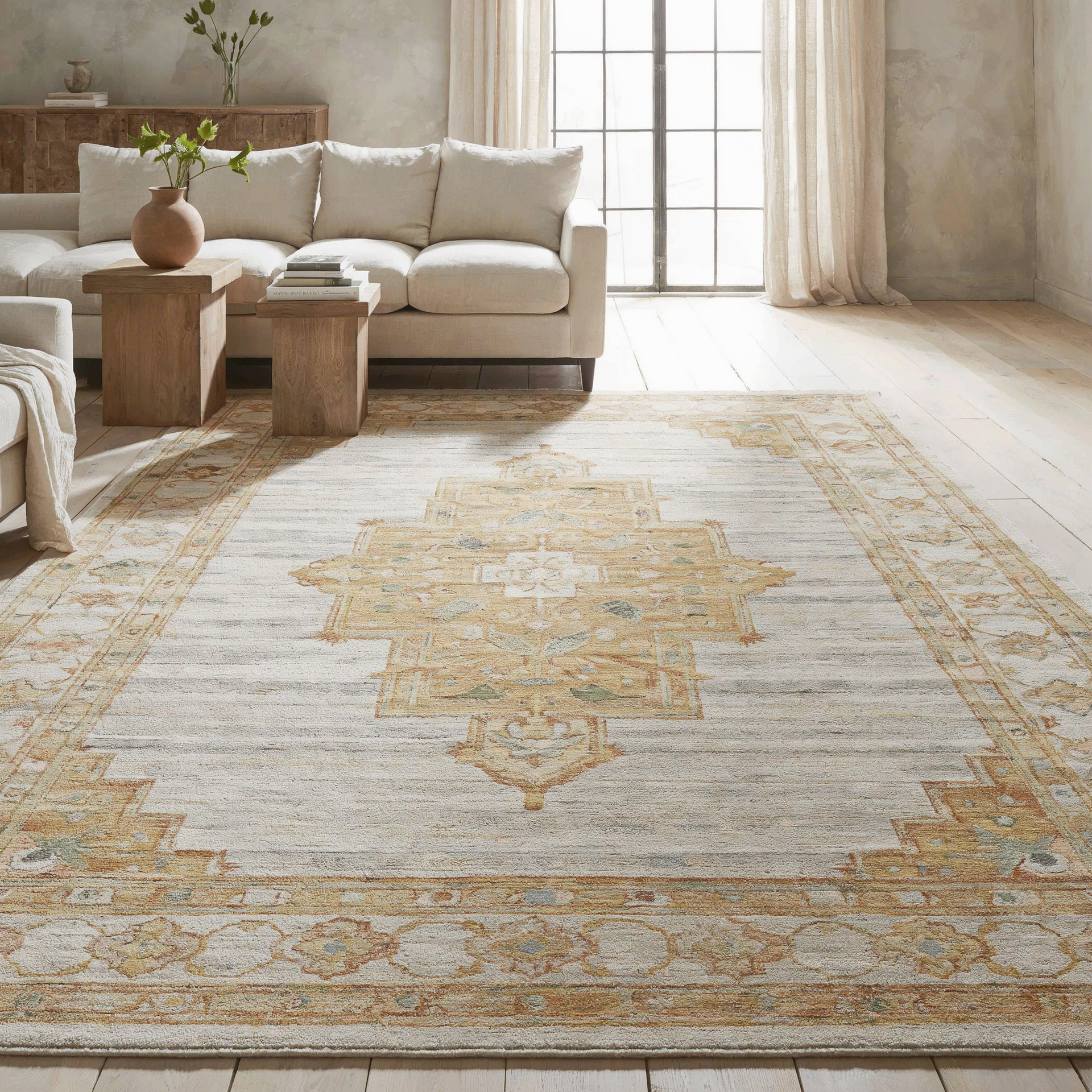 Bright beige living room with sofa, wooden tables, and a cream-and-gold patterned Oushak rug by a window