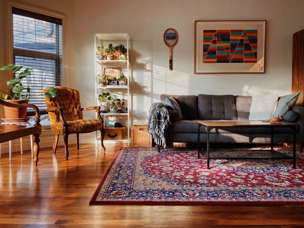Antique Persian rug in sunlit living room, luxury rug restoration Boston MA, First Rugs