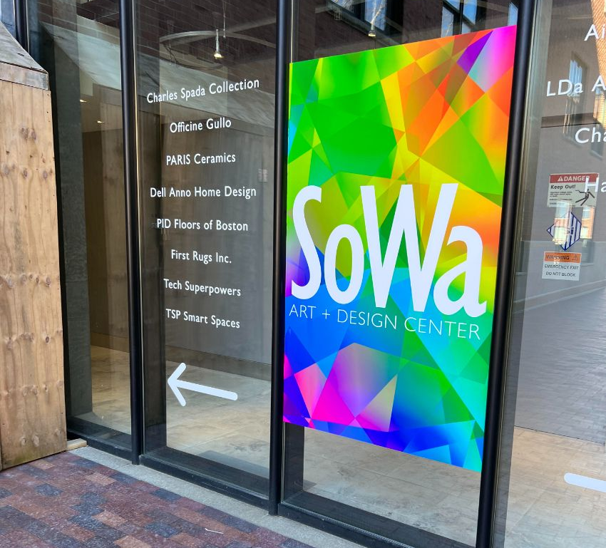 Colorful storefront mural reading “SOWA Art + Design District” on a brick building wall