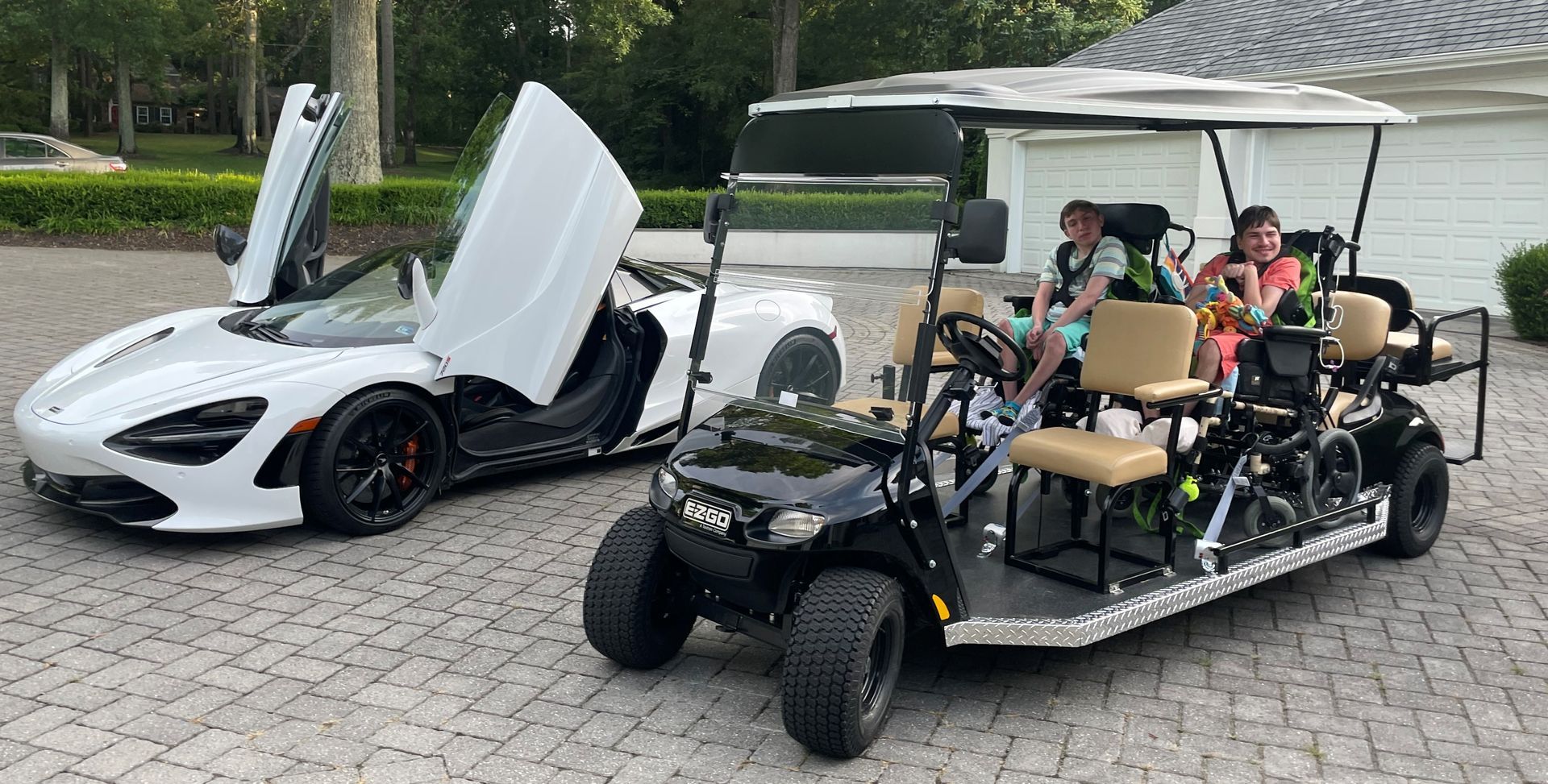 A white sports car and a black golf cart are parked next to each other.