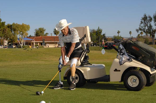 A man in a cowboy hat is swinging a golf club on a golf course