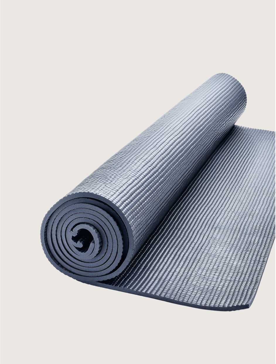 Rolled gray yoga mat with textured surface on a light background