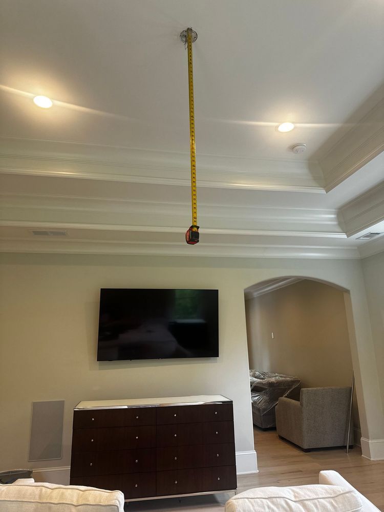 Living room with wall-mounted TV, brown cabinet, and a yellow rope hanging from the ceiling